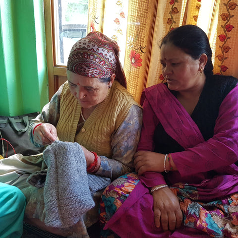 Artisan women in India work together and discuss knitting