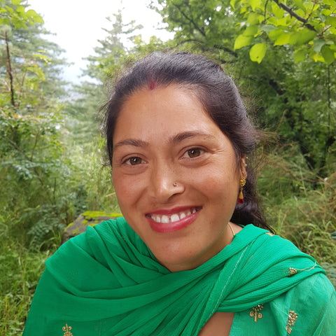 Artisan woman in India smiles brightly wearing green shawl