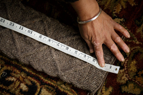 artisan woman measures grey wool cable knit knitted legwarmer