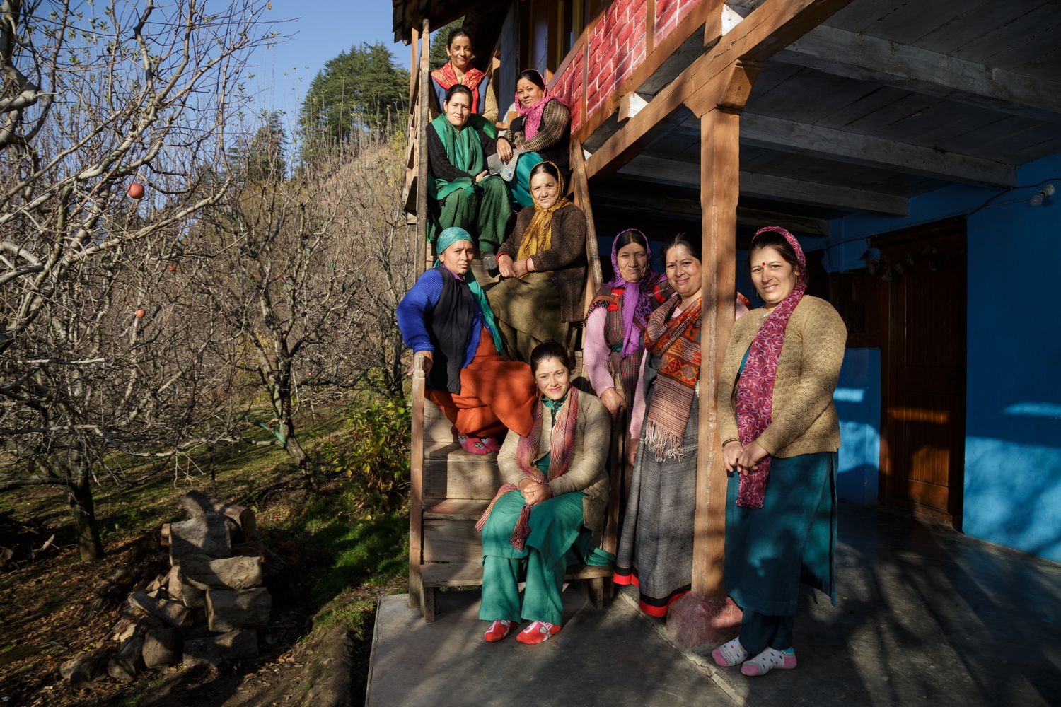 Artisan women of kullvi WHIMS stand on stairs together in sun in Himachal Pradesh India