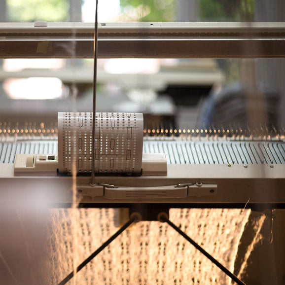 A scarf on a knitting machine.