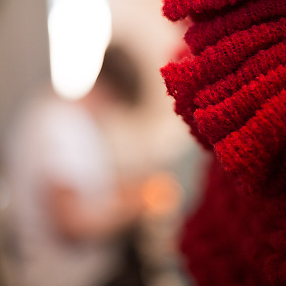 Freshly knitted scarves, with Olena sewing in the background.