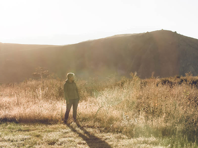 Jules Taylor standing in a Marlborough vineyard amongst lots of native wildflowers and grasses