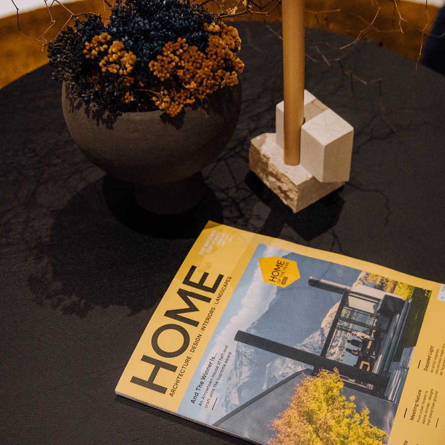 Home magazine on coffee table with candle holder and dried floral display