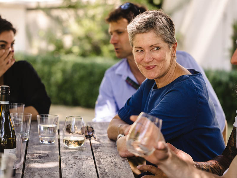 People at outdoor table enjoying wine and conversation