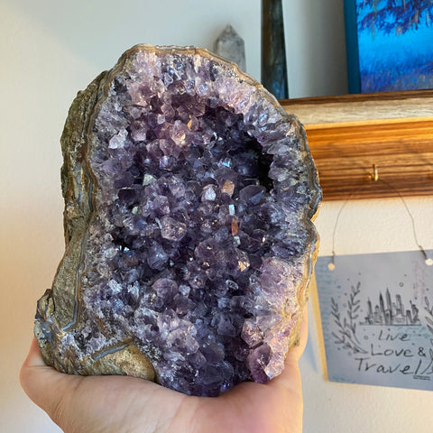 a large piece of purple amethyst sits in a woman's hand