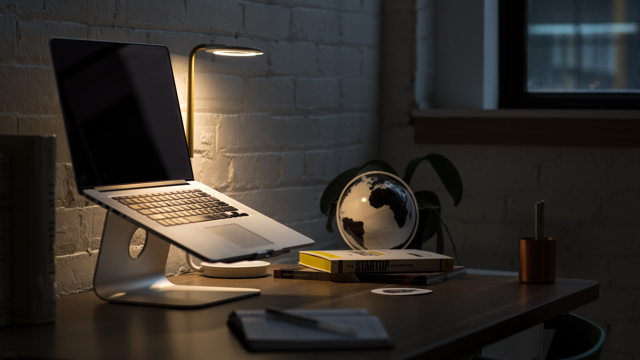 A dimly lit laptop on a desk