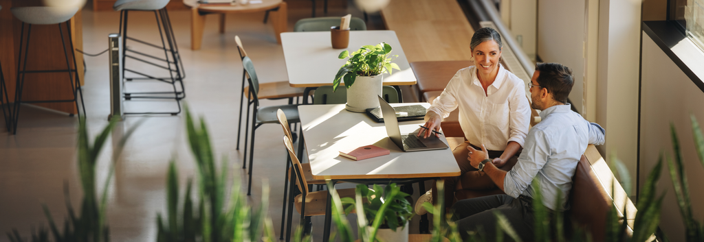 Photo of a man and a woman looking at a laptop at a table