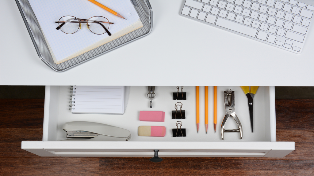 photo of an open desk drawer with office supplies showing