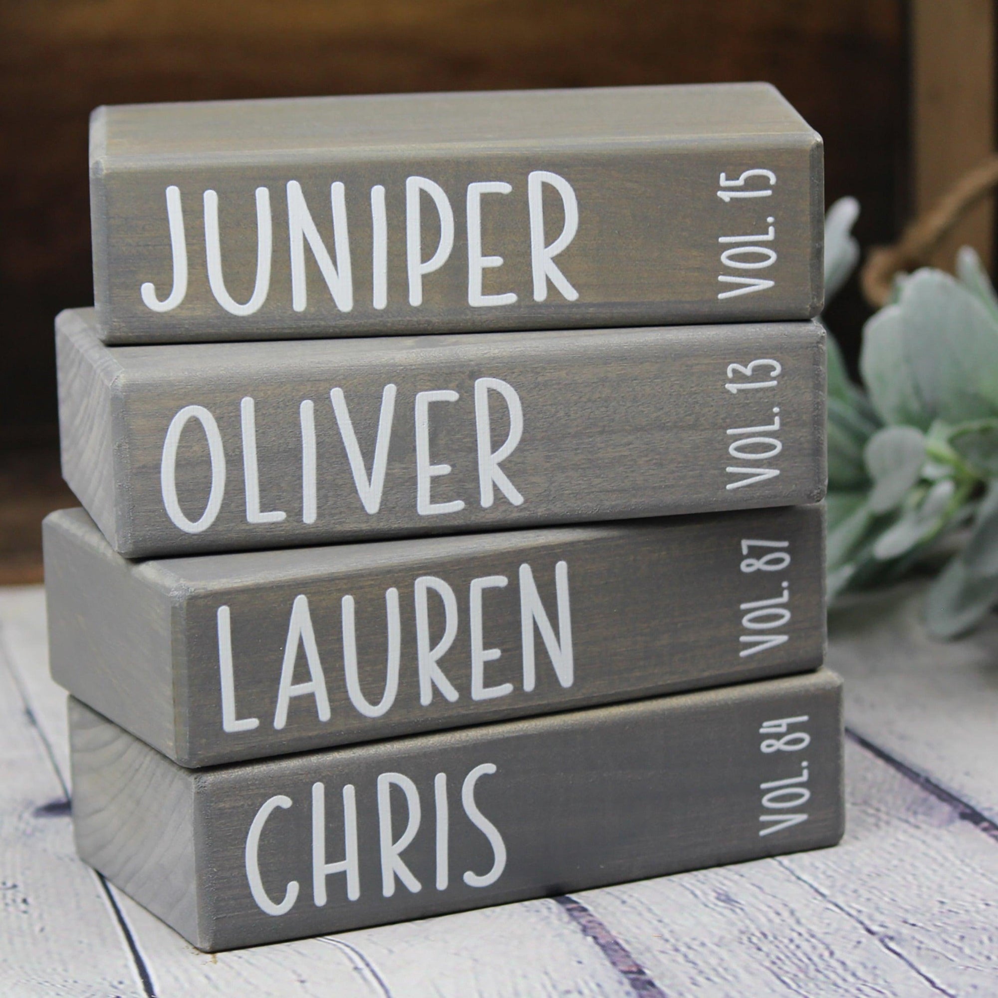 Stack of wooden family books personalized with names and birth years