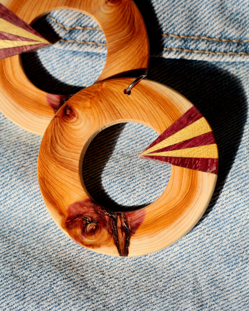 wood hoop earring with sunburst detail close-up on denim background