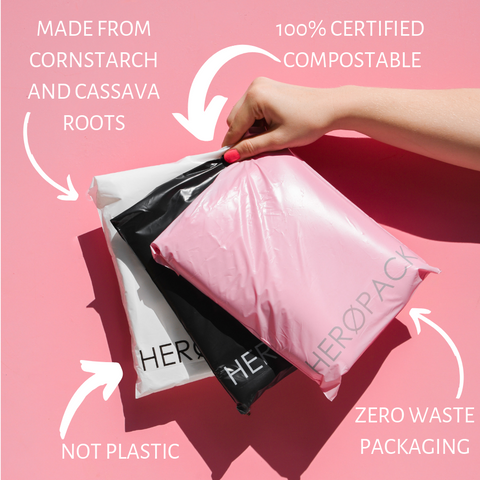 Hand holding three Hero mailers, one white, one black, and one pink, with text reading '100% Certified Compostable', Zero Waste', 'Made from cornstarch and cassava roots', and 'No Plastic.