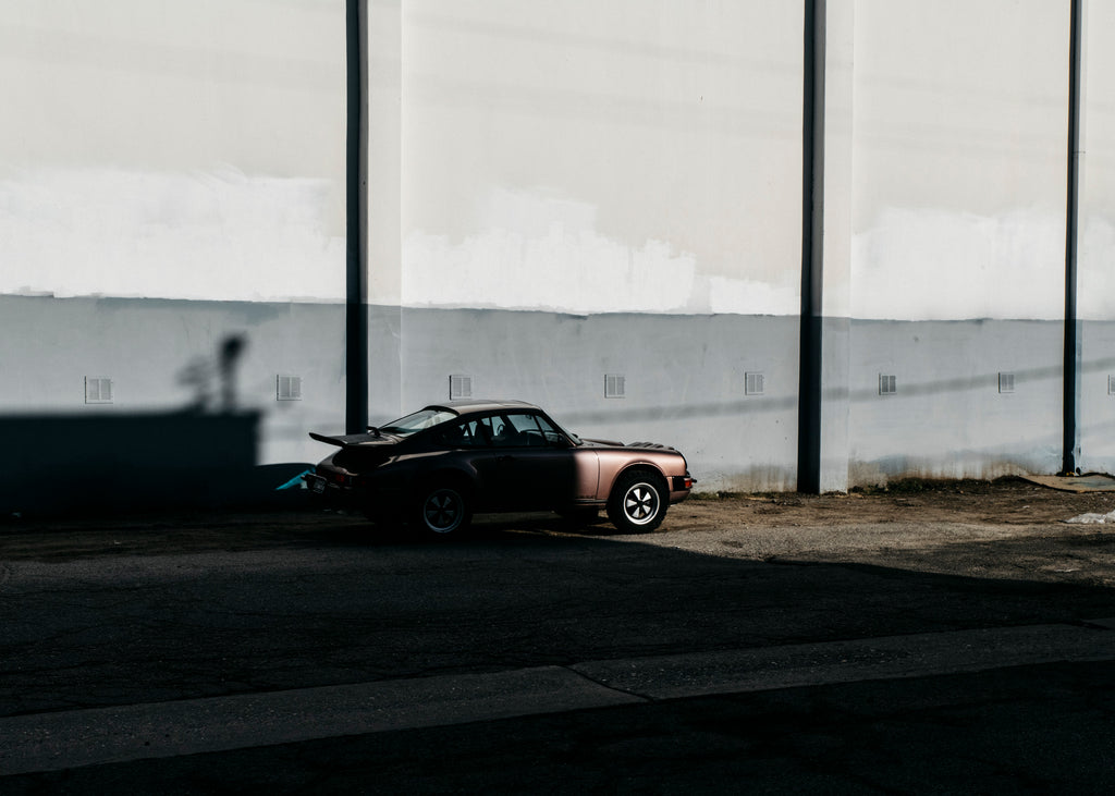 Cassis Red Metallic Porsche 911 Safari half in shadow with gray wall
