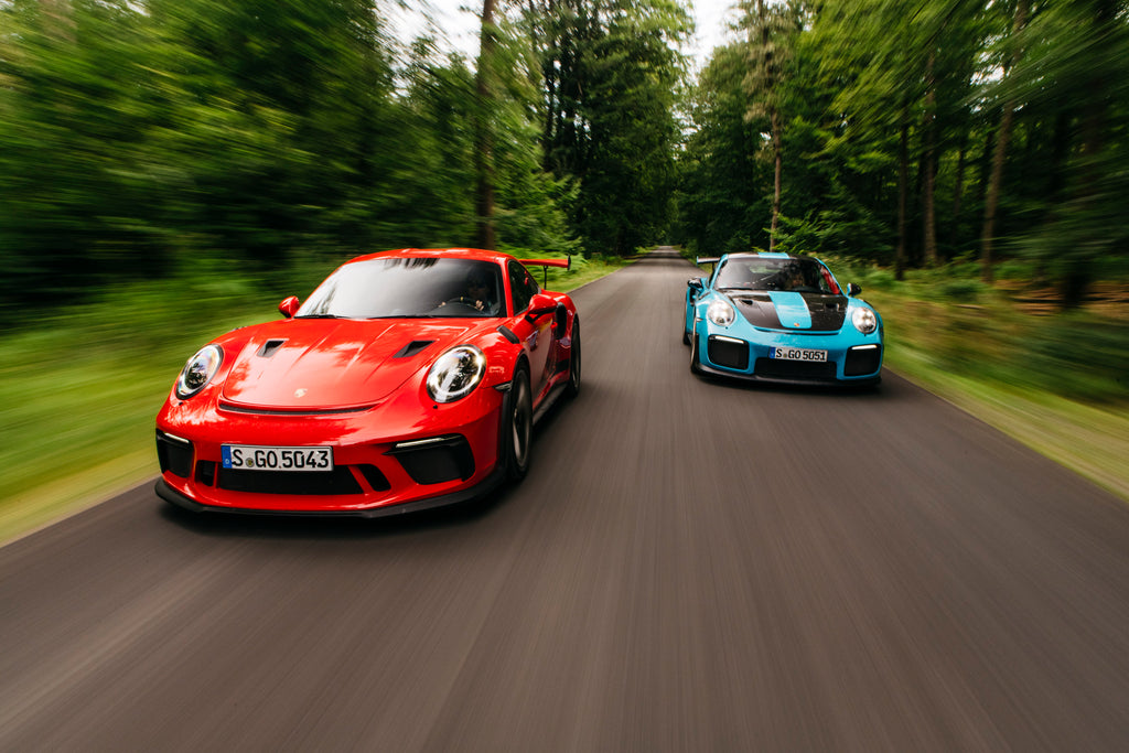 Rolling shot of Guards Red Porsche 911 GT3 RS and Miami Blue Porsche 911 GT2 RS in Belgium