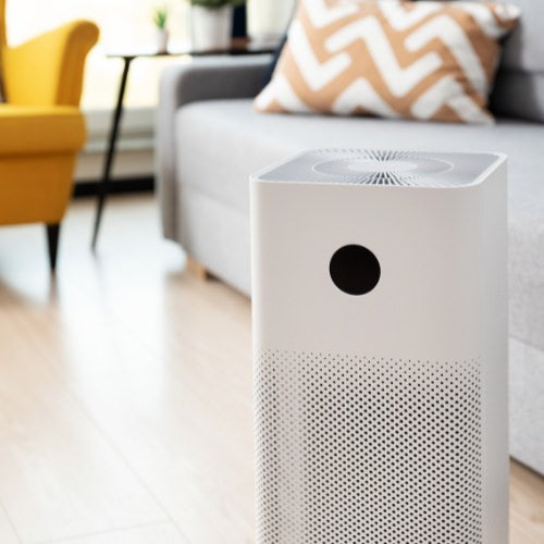 White air purifier in living room cleaning the air of smoke