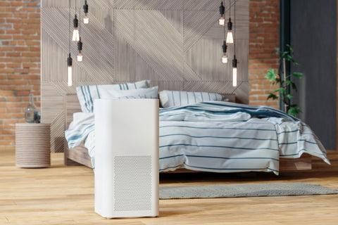 air purifier or humidifier for allergies - white air purifier in front of a bed on the floor