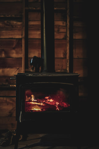 Wood stove ablaze in a rustic setting, a scenario that benefits from the best air purifier for wood stove smoke.