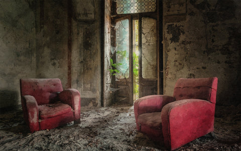 Red chairs covered in dust in an old room, a setting that would benefit from a dust mite air purifier to improve air quality.