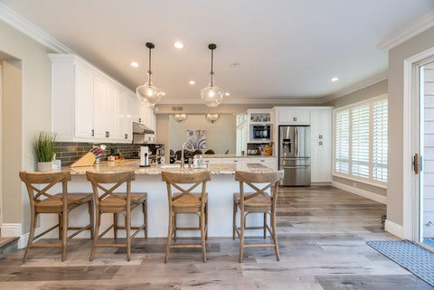 Modern spacious kitchen interior with marble countertops, rustic bar stools, and elegant pendant lighting, perfect for incorporating a large air purifier to maintain clean air quality.