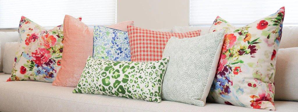 Assorted throw pillows lay artfully on a beige couch