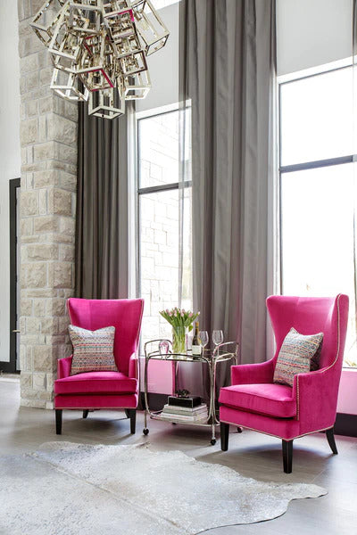  Two fuchsia armchairs draw the eye to a masterfully created living space designed by interior designer Lisa Gielincki.
