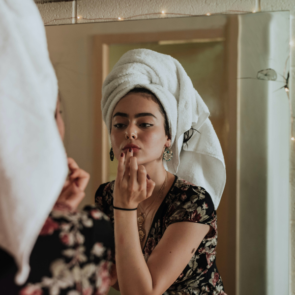 woman doing skincare in bathroom mirror
