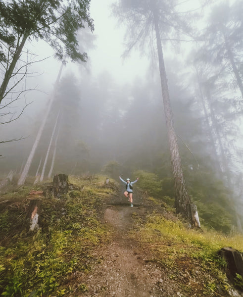 Female runner in foggy forest