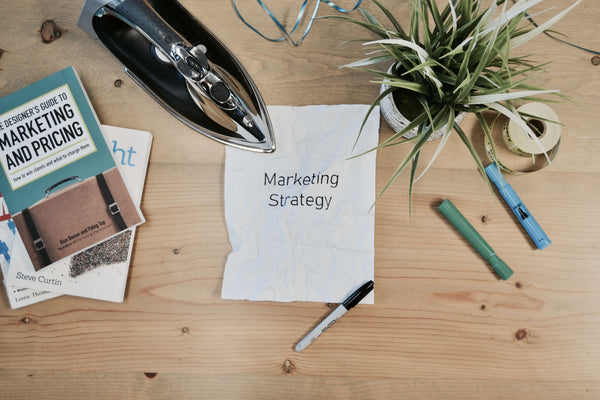 A desk table showing an iron on a piece of paper saying digital strategy 