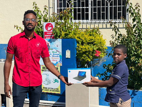 Matthew Wallace giving laptop to primary school in Sav in Jamaica