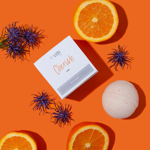 Cherish CBD bath bomb and package surrounded by orange slices