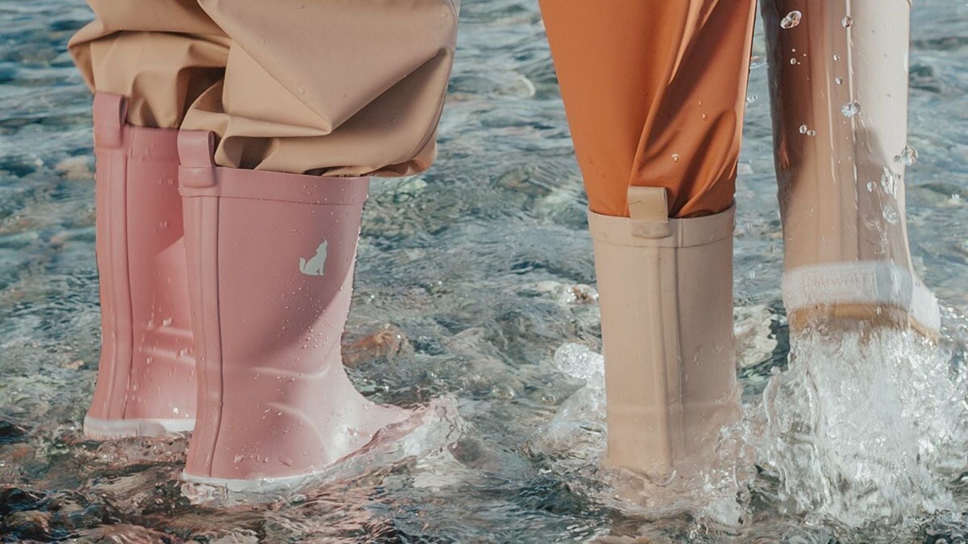 Close up of kids in gumboots in a river