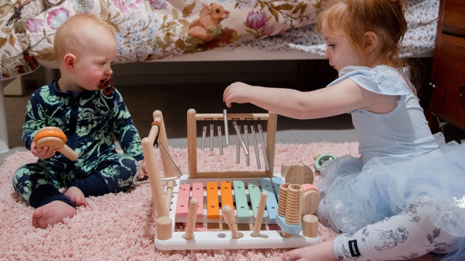 Two young children playing with a Melody Mix music maker