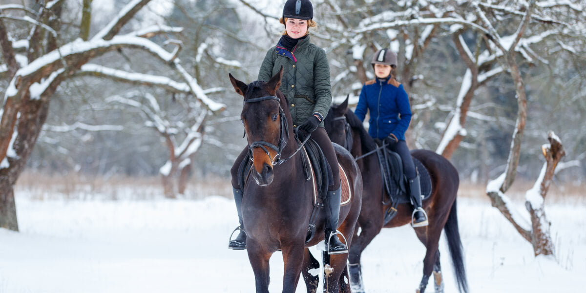 Zwei Reiterinnen Frauen reiten auf ihren Pferden im Schnee