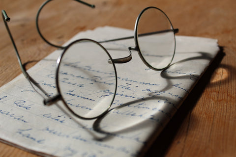 eyeglasses on top of a written paper