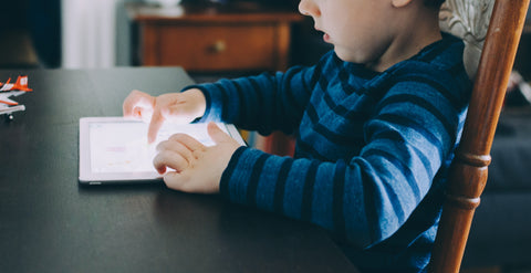 child using a tablet where the screen is bright