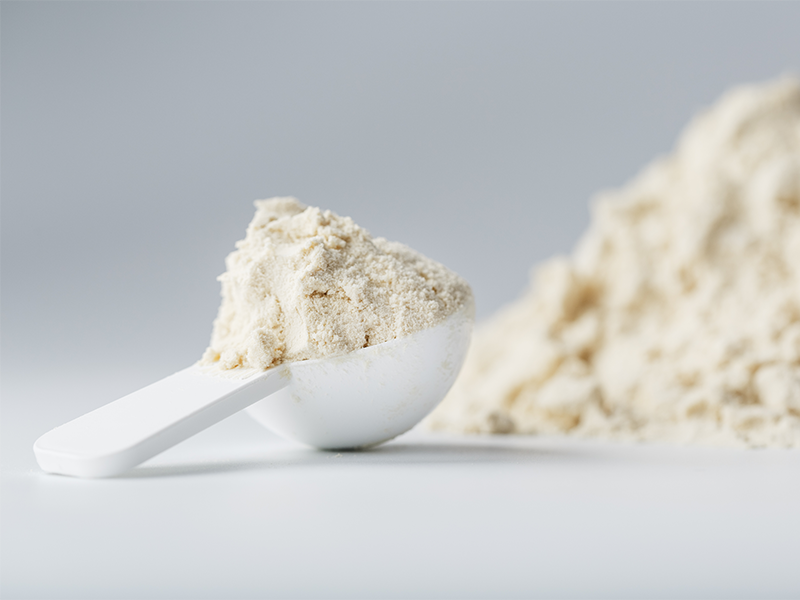 Pile of whey protein powder with scoop