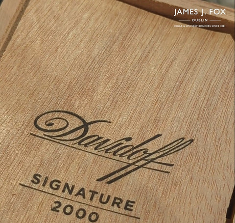 Open Davidoff 2000 cigar box with branded cedar wrap concealing the cigars.