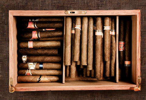 A wooden cigar humidor filled with various sizes and colors of cigars.