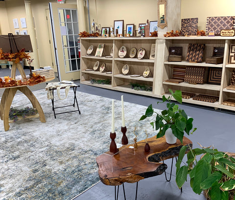 Heirloom Emporium retail gallery, featuring a display of hand painted decorative wood canvases and geometric cutting boards.