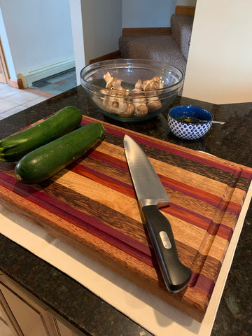 Cutting board with unchopped zucchini and baby bella mushrooms