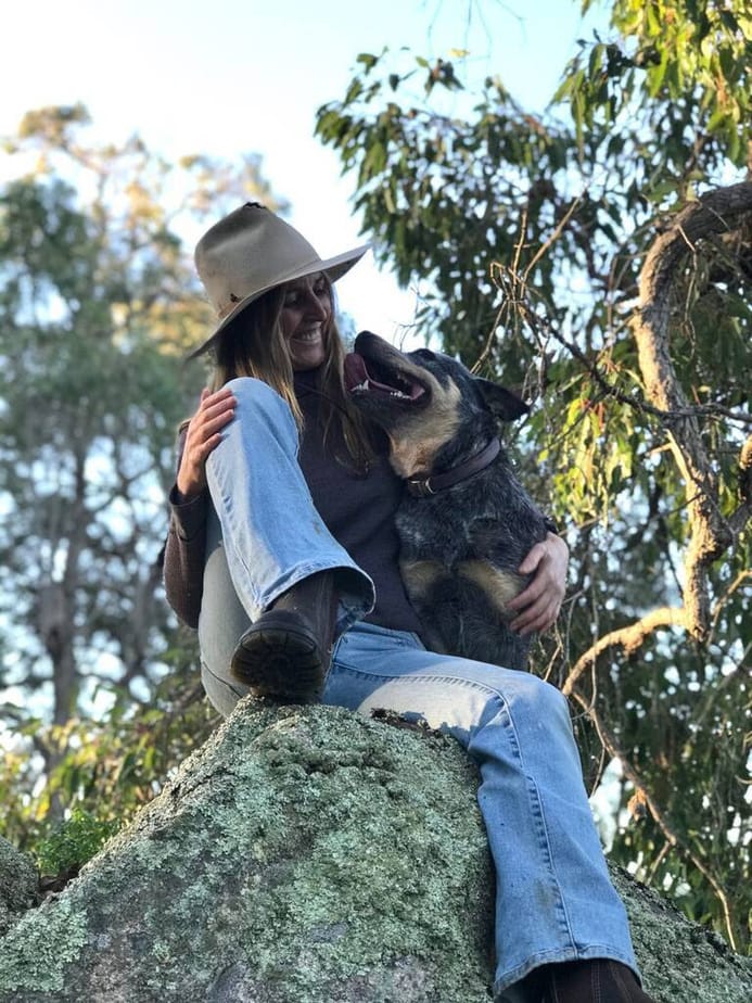 Lori and a dog sitting on a rock