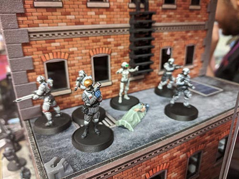 miniature soldiers gathered on a tiny, detailed brick building