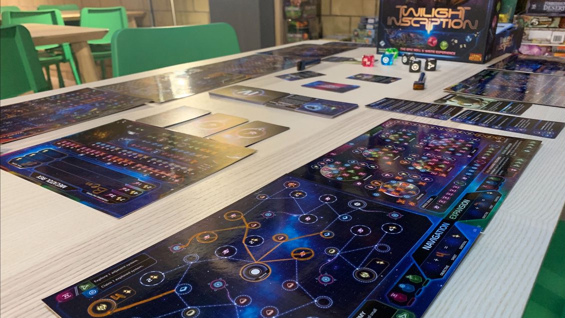 Twilight Inscription includes four dry-erase sheets per person and six large translucent dice. Moves are made in orange marker and everything has a deep blue space-y background