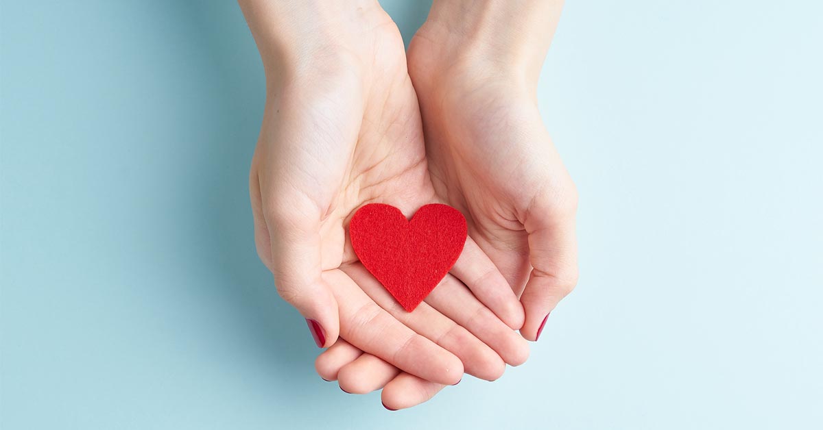 Two hands cradling a red heart, symbolizing the care and appreciation offered through military discount, veteran discount, and service member discount programs.