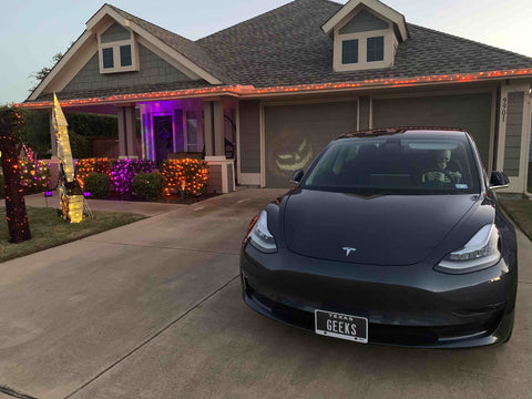 Our Tesla with our house decorated for Halloween.