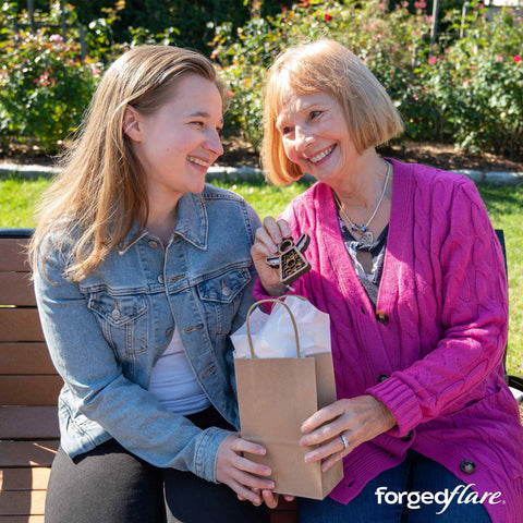 Mother and daughter smiling over a Mother's Angels ornament