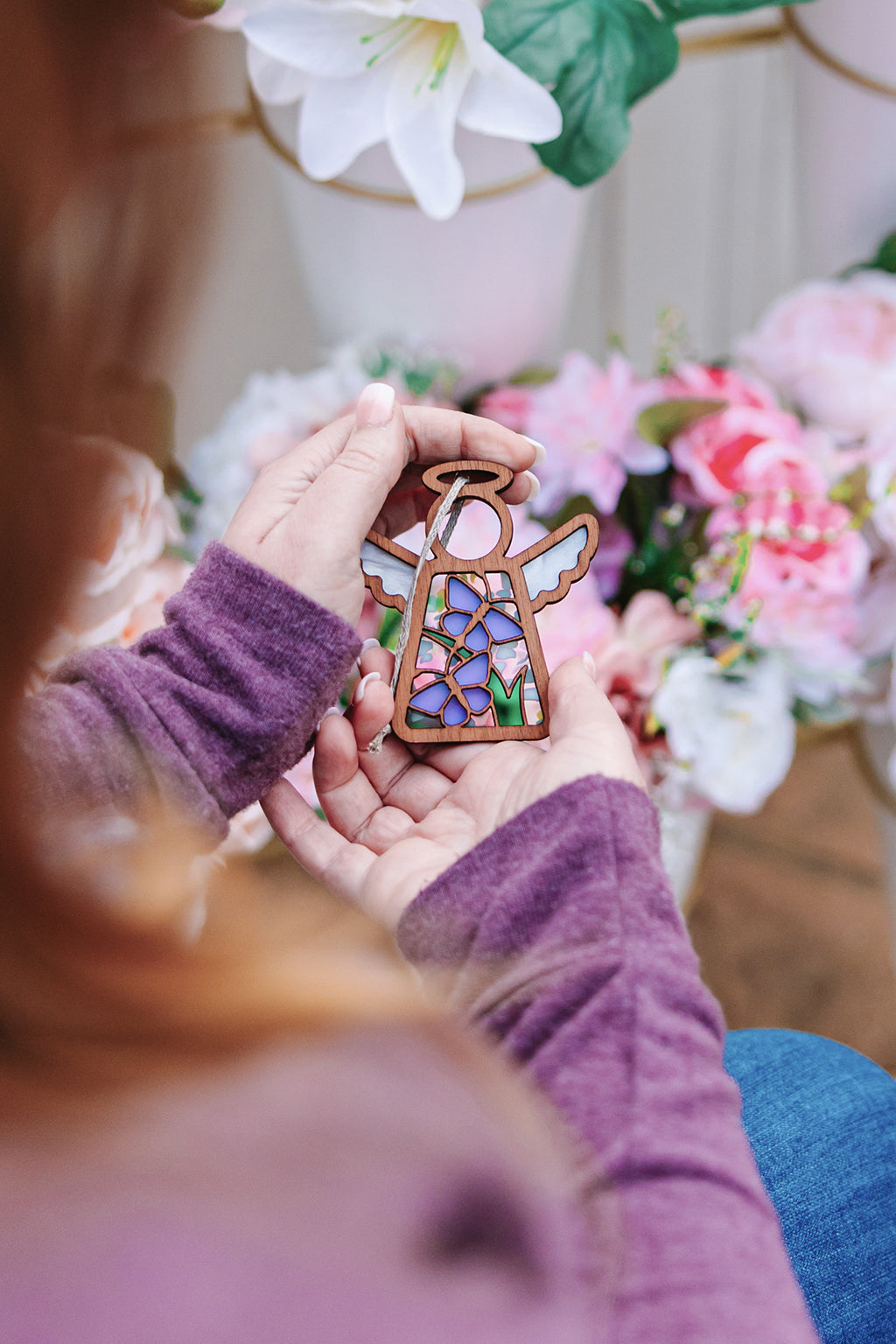 A woman admiring the Mother’s Angels® Playful Purple Butterflies ornament.