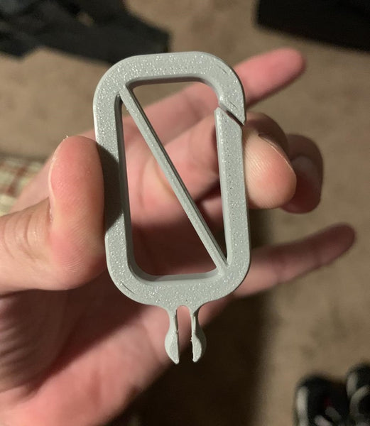 A 3D-printed carabiner clip that holds one pickleball