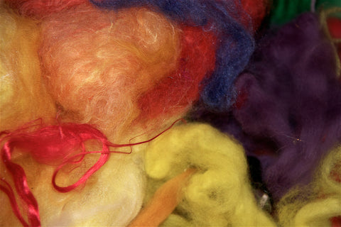 Scottish wool fabric in process of dying in colors red, yellow, purple, blue and orange