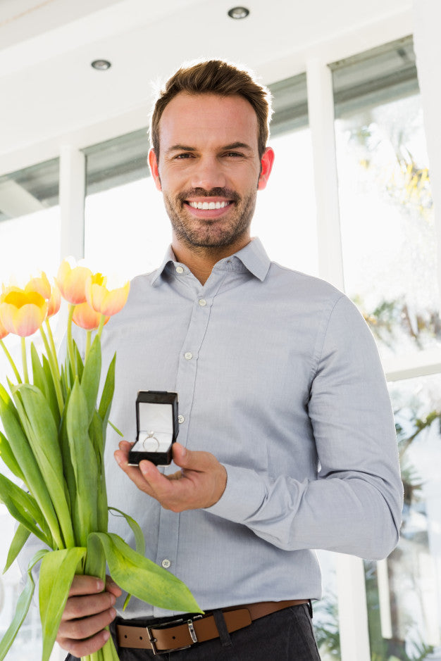 man holding a flower and a ring proposing for a marriage